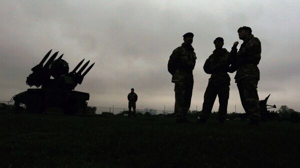 Members of the British military's Royal Artillery regiment are silhouetted as they stand near a Rapier air defence system during a media event ahead of a training exercise designed to test military procedures prior to the Olympic period in Blackheath, London - Sputnik International