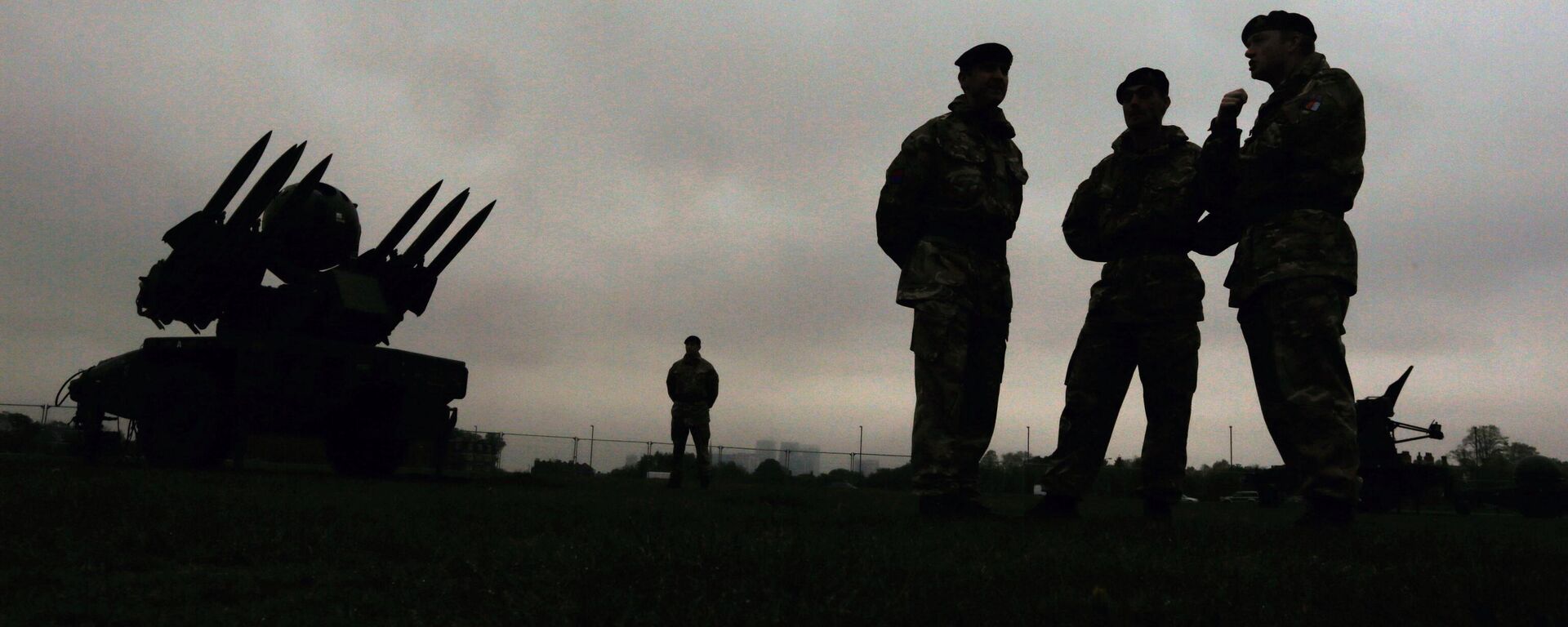 Members of the British military's Royal Artillery regiment are silhouetted as they stand near a Rapier air defence system during a media event ahead of a training exercise designed to test military procedures prior to the Olympic period in Blackheath, London - Sputnik International, 1920, 26.07.2024