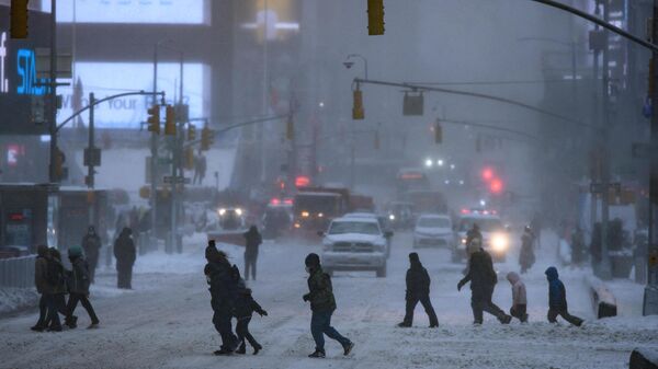 Pedestrians cross a street during a winter storm in New York on January 29, 2022.  - Sputnik International