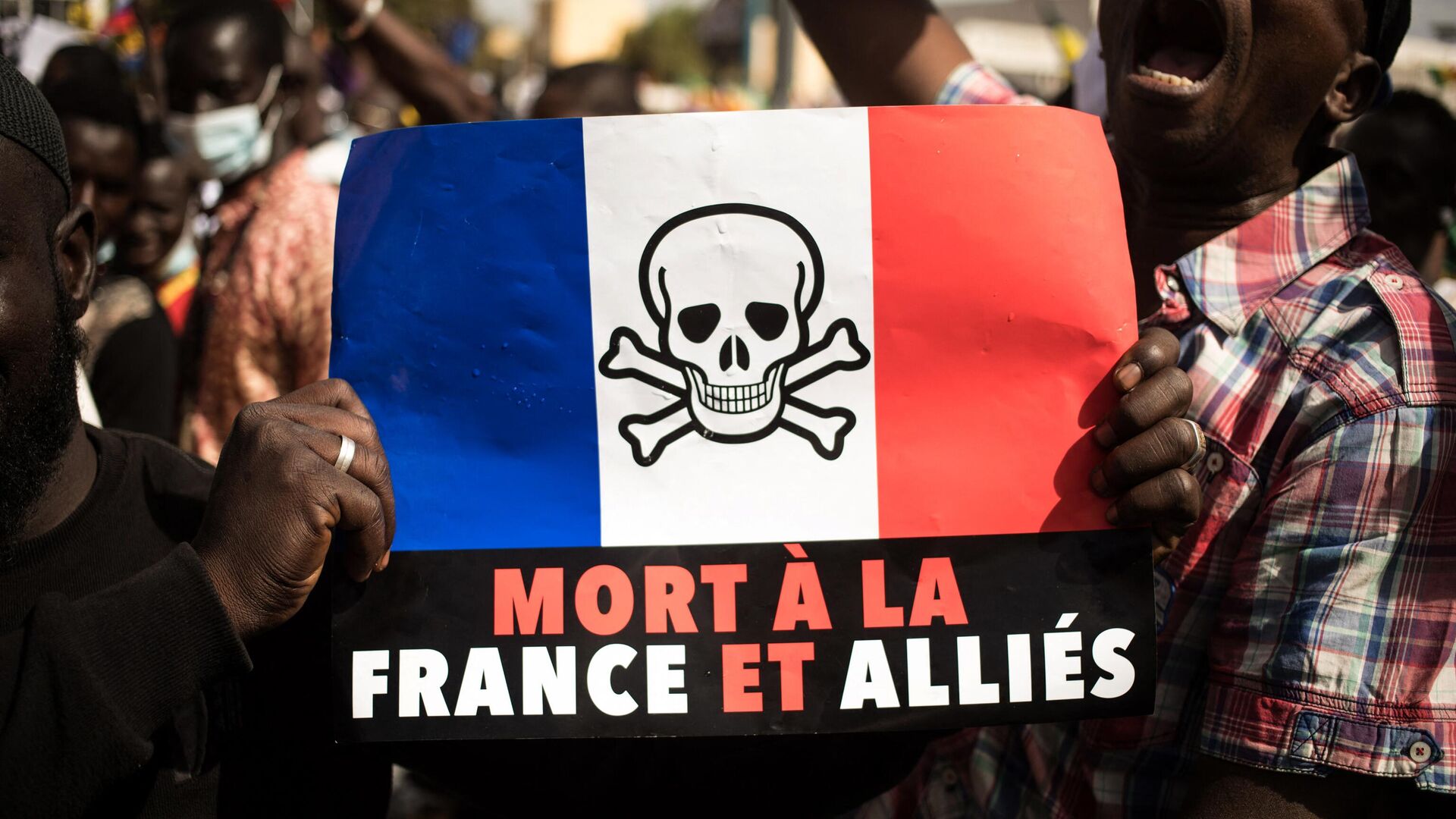 Demonstrators hold up a that reads, Death to France and its allies, during a mass demonstration to protest against sanctions imposed on Mali and the Junta, by the Economic Community of West African States (ECOWAS), in Bamako on January 14, 2022. - Sputnik International, 1920, 22.11.2022