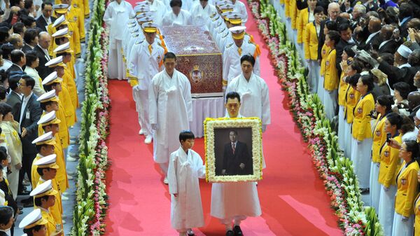Relatives of late Unification Church founder Sun Myung Moon carry a portrait as honor guards carry a coffin containing the body of Moon (C) as they leave from his funeral ceremony at the Cheongshim Peace World Center in Gapyeong, about 60 km east of Seoul, on September 15, 2012. - Sputnik International