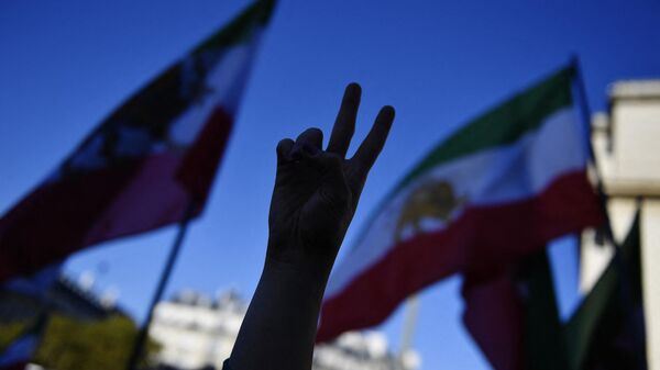 A demonstrator gestures a peace sign during a rally in support of Iranian protests, in Paris,on October 9, 2022, following the death of Iranian woman Mahsa Amini in Iran - Sputnik International