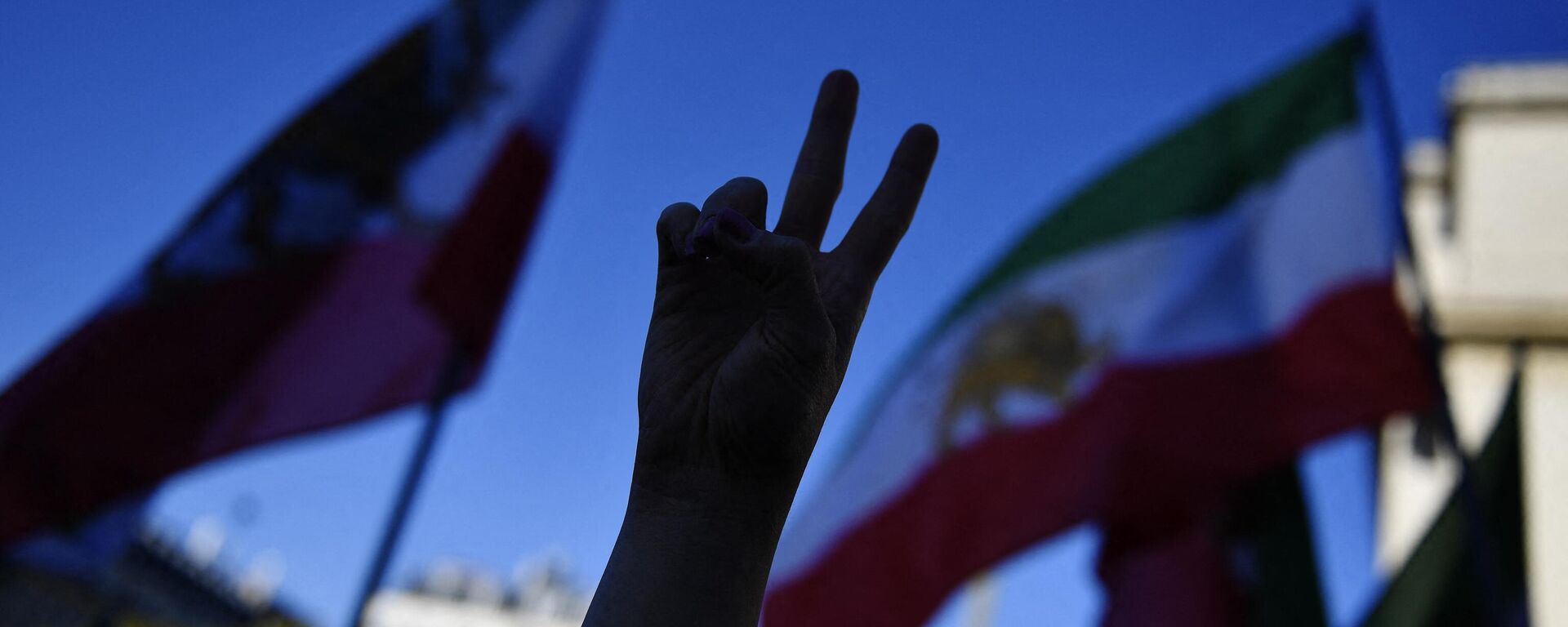 A demonstrator gestures a peace sign during a rally in support of Iranian protests, in Paris,on October 9, 2022, following the death of Iranian woman Mahsa Amini in Iran - Sputnik International, 1920, 23.11.2022