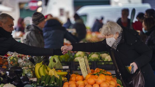 An elderly woman buys food in a market in Florence, Italy, Thursday, Feb. 17, 2022 - Sputnik International