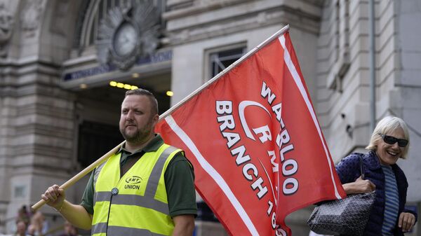 A member of the Rail, Maritime and Transport union (RMT) stands at the entrance to Waterloo Station as members began fresh nationwide strikes - Sputnik International