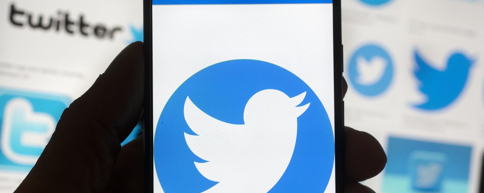 The Twitter logo is seen on a cell phone, Friday, Oct. 14, 2022, in Boston.  The “official” designation for major corporate accounts on Twitter appeared, vanished, and depending on the account, appeared or vanished again and some companies took to the social media platform to warn of imposters. - Sputnik International, 1920, 06.01.2023