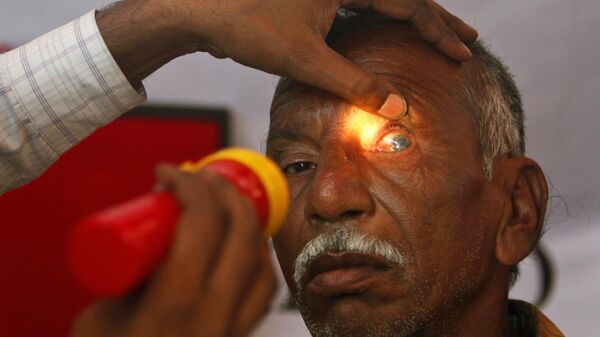 An Indian optician checks the eye of an elderly man at a free check-up camp at a shanty town to mark World Sight Day in Hyderabad, India, Thursday, Oct. 14, 2010. - Sputnik International