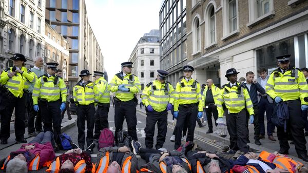 Handcuffed activists from the group Just Stop Oil lie on the road as they are arrested after they blocked a road in London - Sputnik International