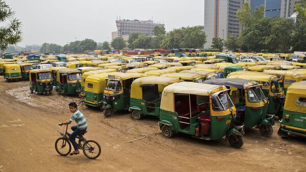 A young boy cycles past scores of three wheelers called autos parked during a commercial auto and taxi strike in New Delhi, India, Tuesday, July 26, 2016. - Sputnik International