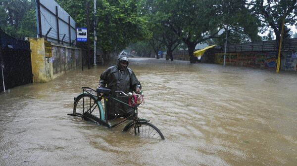 A man pushes his cycle past a flooded street in Chennai, in the southern Indian state of Tamil Nadu, Thursday, Nov. 11, 2021. - Sputnik International