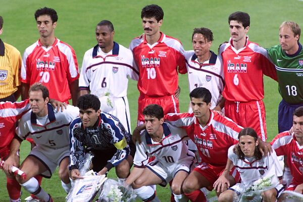 Players from the two teams took a 22-person photo together before the match kicked off.Above: USA and Iran pose together on June 21 at the Gerland stadium in Lyon, central France, before their 1998 World Cup Group F match. - Sputnik International