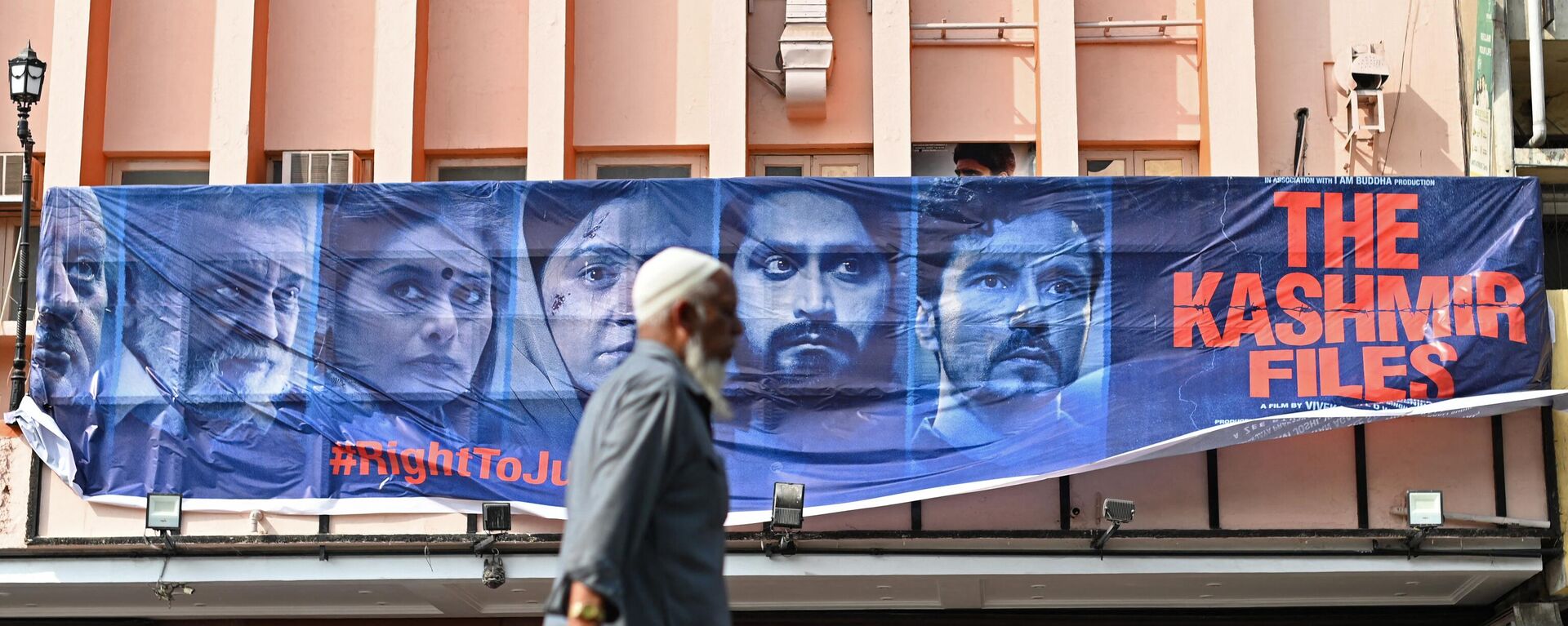 A man walks past a banner of Bollywood movie 'The Kashmir Files' installed outside a cinema hall in the old quarters of Delhi on March 21, 2022. - Sputnik International, 1920, 29.11.2022