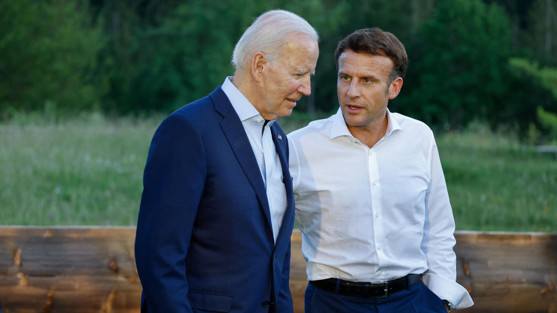 US President Joe Biden and French President Emmanuel Macron speak after posing for an informal group photo at a bench after a working dinner during the G7 Summit held at Elmau Castle, southern Germany on June 26, 2022. - Sputnik International, 1920, 01.12.2022
