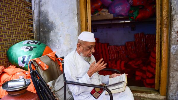 A Muslim man prays beside stacks of canvassing cloth of Bharatiya Janata Party (BJP) at a workshop, ahead of India’s Gujarat state assembly elections in Ahmedabad on November 12, 2022. - Sputnik International