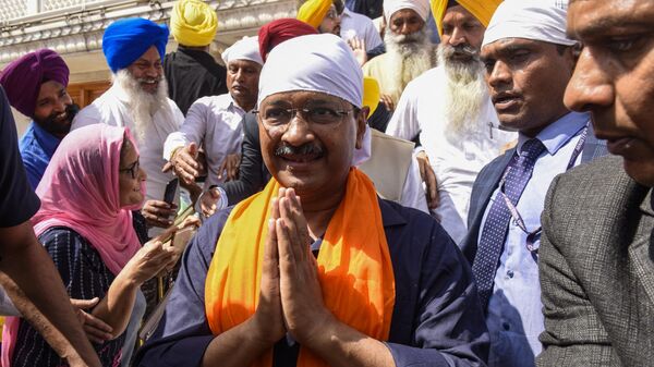 Aam Aadmi Party (AAP) leader and Delhi's Chief Minister Arvind Kejriwal (C) pay respects at the Golden Temple in Amritsar on March 13, 2022. - Sputnik International