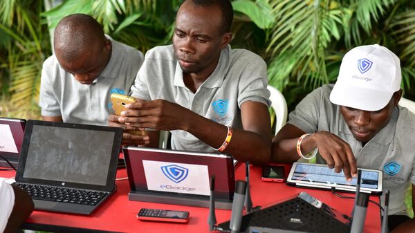 Visitors look at computers, phones and tablets by e-badge on the first day of the 2016 Africa Web Festival (AWF) in Abidjan on November 29, 2016. - Sputnik International