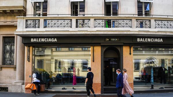 People walk past a Balenciaga luxury goods shop on May 18, 2020 in central Milan. - Sputnik International