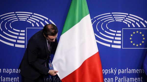 An European Parliament worker sets the Italian flag ahead of the visit of the newly appointed Italian Prime Minister (not pictured) at the European Parliament headquarters in Brussels, Belgium, on November 3, 2022.  - Sputnik International