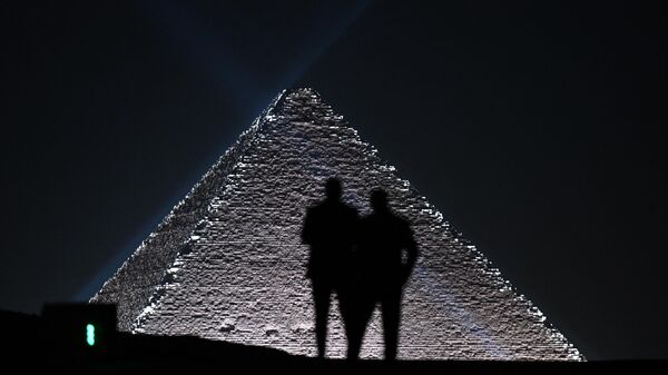 Models are silhoutted against the Pyramids at the Christian Dior fashion show at the Giza Pyramids Necropolis on the outskirts of the twin city of Egypt's capital on December 3, 2022.  - Sputnik International