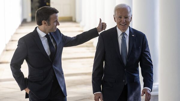 US President Joe Biden and French President Emmanuel Macron walk down the Colonnade at the White House in Washington, DC, on December 1, 2022.  - Sputnik International