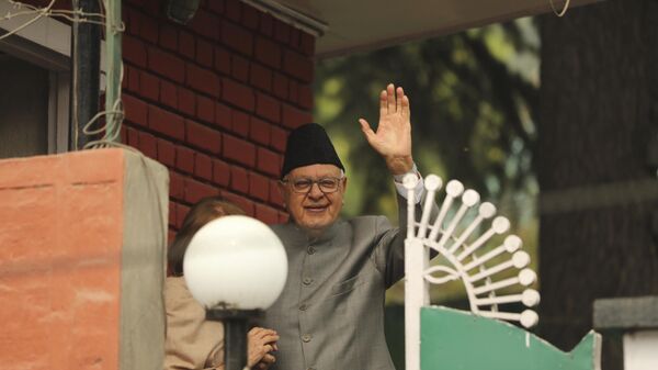 Former Chief Minister of Jammu and Kashmir and National Conference party president Farooq Abdullah, right, waves towards the media persons as he arrives with his wife Molly Abdullah, partly seen on left, to meet his party colleagues inside their residence in Srinagar, Indian controlled Kashmir, Sunday, Oct. 6, 2019. - Sputnik International