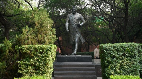 In this photograph taken on October 28, 2022, a pedestrian walks past a statue of India's first prime minister Jawaharlal Nehru on the campus of Jawaharlal Nehru University in New Delhi. - Sputnik International