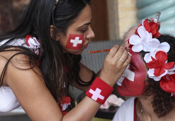 A Switzerland supporter gets her face painted at the Souq Waqif market in Doha, ahead of the Qatar 2022 World Cup football match between Brazil and Switzerland, on November 28, 2022. (Photo by MAHMUD HAMS / AFP) - Sputnik International