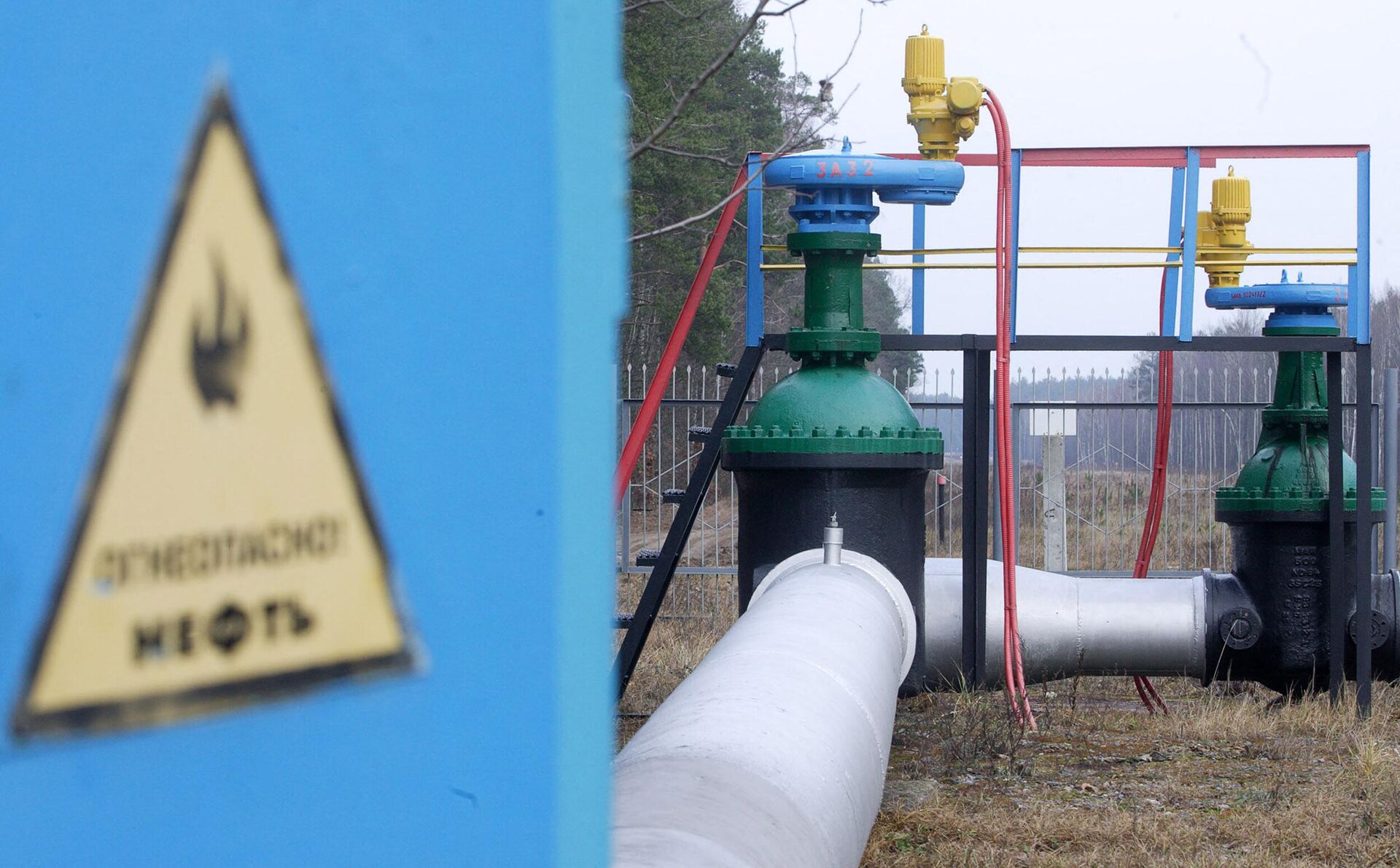 A discharge valve of oil pipeline Druzhba is seen behind a fence at a village of Romanovka in Mozyr's region of Belarus, 10 January 2007.  - Sputnik International, 1920, 09.12.2022