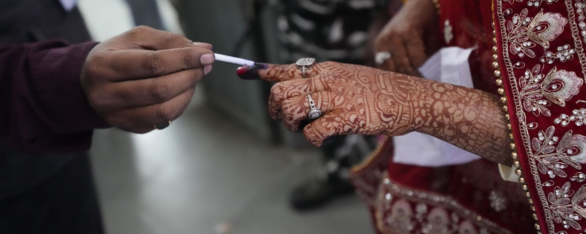 A election officer applies indelible ink mark on the index finger of a bride during the second phase of Gujarat state legislature elections in Ahmedabad, India, Monday, Dec. 5, 2022. - Sputnik International, 1920, 06.12.2022
