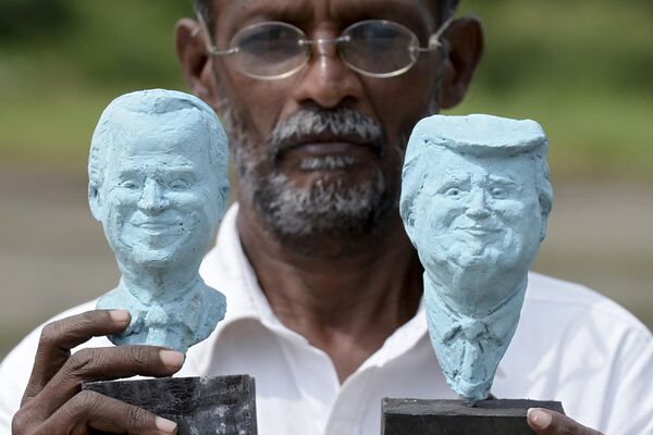 Sri Lankan clay artist Upali Dias poses with the handmade busts of former US President Donald Trump (R) and current President Joe Biden (L) ahead of the 2020 presidential election which Biden won. - Sputnik International