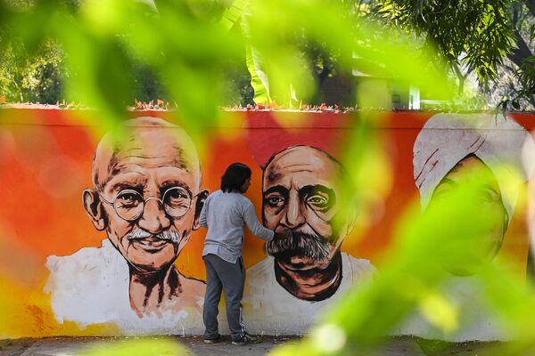 An artist gives the finishing touches to a wall mural depicting prominent figures of the Indian freedom struggle in New Delhi on February 13, 2022. (Photo by Sajjad HUSSAIN / AFP) - Sputnik International