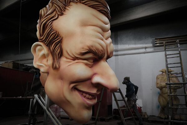 An artist works on a giant caricature of the head of French President Emmanuel Macron created for the upcoming 2022 Nice Carnival, in the French riviera city of Nice on February 9, 2022. (Photo by Valery HACHE / AFP) - Sputnik International