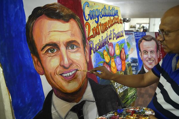 An artist gives the final touches to a painting of French President Emmanuel Macron after his victory in France&#x27;s presidential election, in Mumbai on April 25, 2022. (Photo by Punit PARANJPE / AFP) - Sputnik International