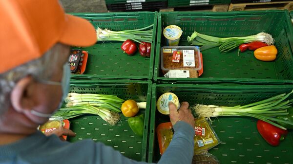 A volunteer sorts vegetables, fruits and other food products in crates at the Tafel, food bank for the needy - Sputnik International