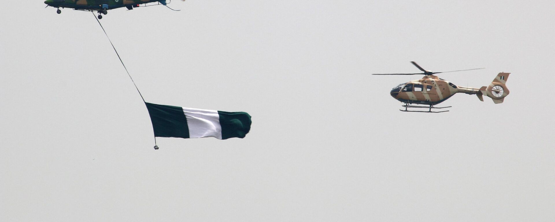 Nigerian Air Force helicopters perfom with the flag of Nigeria during a parade marking the country's 58th anniversary of independence, on October 1, 2018, on Eagle Square in Abuja. - Sputnik International, 1920, 09.12.2022