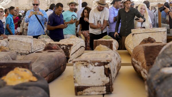 Reporters film painted coffins with well-preserved mummies inside, dating back to the Late Period of ancient Egypt around 500 B.C, displayed during a press conference at a makeshift exhibit at the feet of the Step Pyramid of Djoser in Saqqara, 24 kilometers (15 miles) southwest of Cairo, Egypt, Monday, May 30, 2022. - Sputnik International