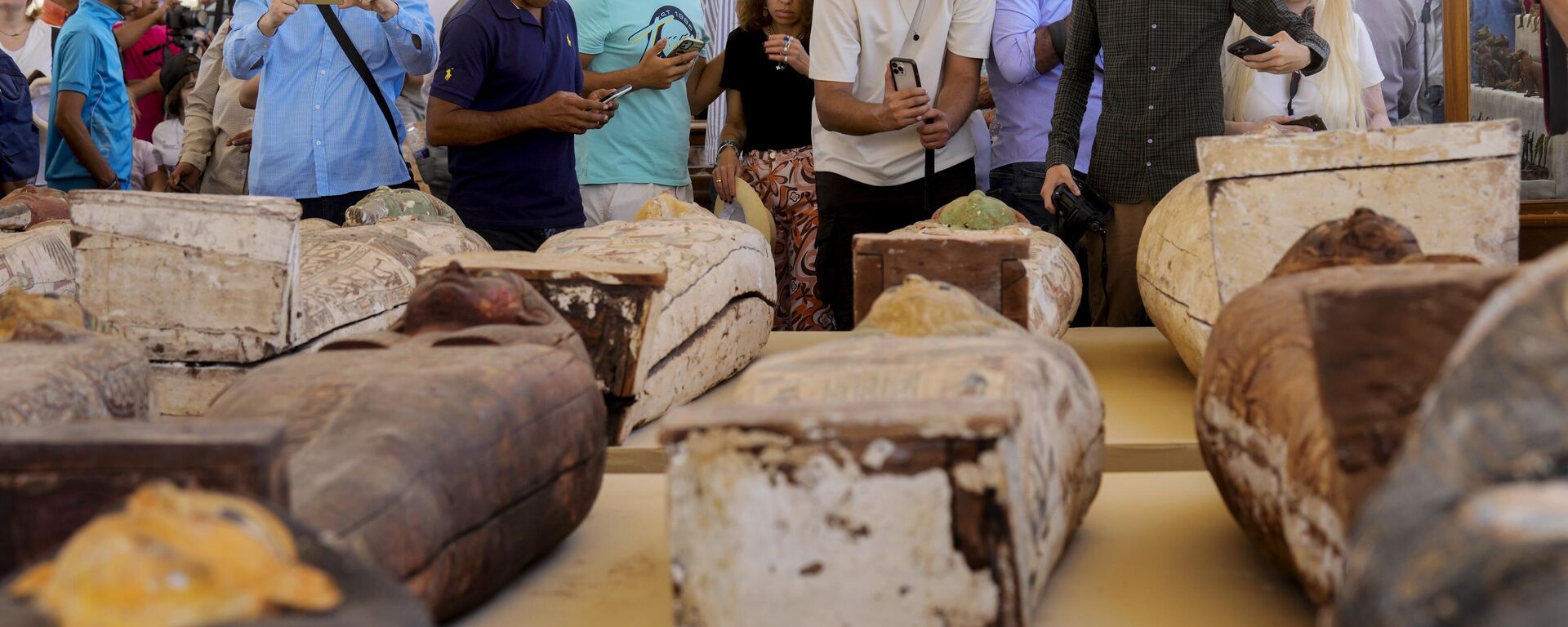 Reporters film painted coffins with well-preserved mummies inside, dating back to the Late Period of ancient Egypt around 500 B.C, displayed during a press conference at a makeshift exhibit at the feet of the Step Pyramid of Djoser in Saqqara, 24 kilometers (15 miles) southwest of Cairo, Egypt, Monday, May 30, 2022. - Sputnik International, 1920, 10.12.2022