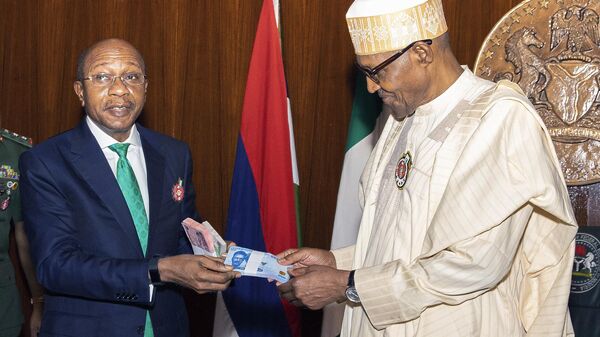 In this photo released by the Nigeria State House, Nigeria's central bank governor, Godwin Emefile, left, presents the newly designed currency notes to Nigeria's President Muhammadu Buhari, right, during a launch in Abuja, Nigeria, Tuesday, Nov. 22, 2022.  - Sputnik International