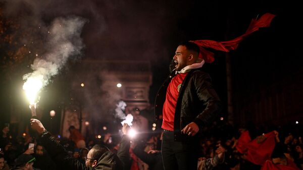 People celebrate Morocco's victory in the Qatar 2022 World Cup quarter-final football match against Portugal on the Champs Elysee avenue in Paris on December 10, 2022 - Sputnik International