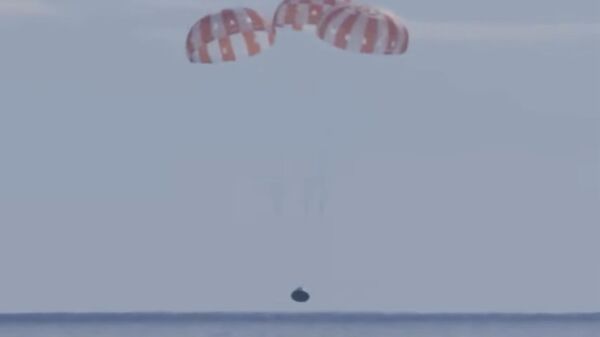 This photo provided by NASA shows the Orion capsule coming back from the moon. The capsule made a blisteringly fast return Sunday, Dec. 11, 2022, parachuting into the Pacific off Mexico to conclude a dramatic 25-day test flight. The mission should clear the way for astronauts on the program’s next lunar flyby, set for 2024.  - Sputnik International