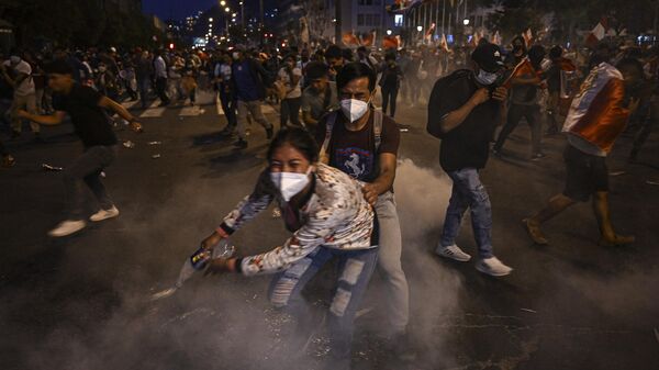 Supporters of former President Pedro Castillo take cover from tear gas thrown by the police during clashes on a demonstration demanding his release and the closure of the Peruvian Congress in Lima, on December 11, 2022. - Sputnik International