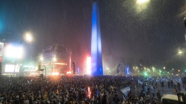 Argentina soccer fans gather despite a downpour at their iconic obelisk to celebrate their team's World Cup quarterfinal victory over The Netherlands, in Buenos Aires, Argentina - Sputnik International