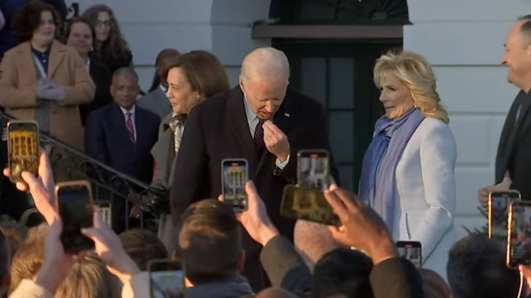 Joe Biden prepares to swallow mystery item given to him by First Lady Jill Biden during a ceremony at the White House on Tuesday, December 13, 2022. Screengrab of YouTube video. - Sputnik International