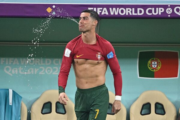 Portugal&#x27;s forward #07 Cristiano Ronaldo spits out water during the Qatar 2022 World Cup round of 16 football match between Portugal and Switzerland at the Lusail Stadium in Lusail, north of Doha, December 6, 2022. - Sputnik International