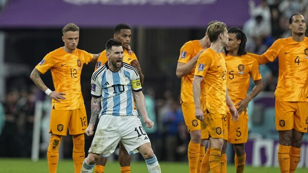 Аргентинец Лионель Месси празднует победу перед игроками Нидерландов на ЧМ в Катаре - Sputnik International