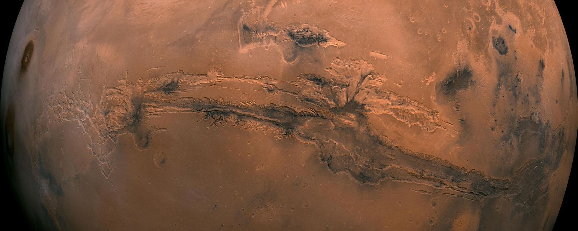 This mosaic of Mars is a compilation of images captured by the Viking Orbiter 1. The center of the scene shows the entire Valles Marineris canyon system, more than 2,000 miles (3,000 kilometers) long, 370 miles (600 kilometers) wide and 5 miles (8 kilometers) deep, extending from Noctis Labyrinthus, the arcuate system of graben to the west, to the chaotic terrain to the east. - Sputnik International, 1920, 18.10.2023