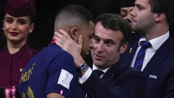 France's Kylian Mbappe is consoled by French President Emmanuel Macron after the World Cup final - Sputnik International