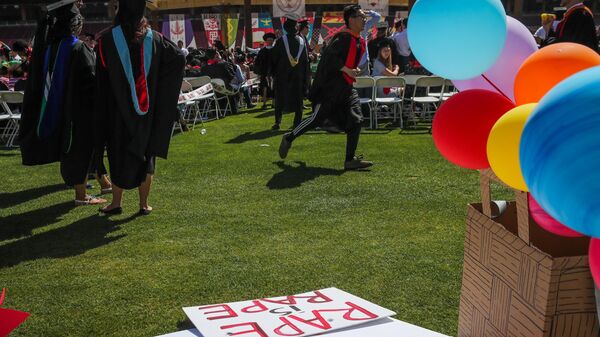 Students walk by a sign that lays on the ground that was made in support of a Stanford rape victim, during graduation ceremonies at Stanford University, in Palo Alto, California, on June 12, 2016.  - Sputnik International