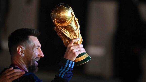 Argentina's captain and forward Lionel Messi holds the FIFA World Cup Trophy on December 20, 2022.  - Sputnik International