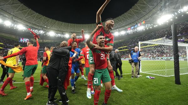 Morocco's players celebrate after winning the World Cup quarterfinal soccer match between Morocco and Portugal, at Al Thumama Stadium in Doha, Qatar, Saturday, Dec. 10, 2022. - Sputnik International
